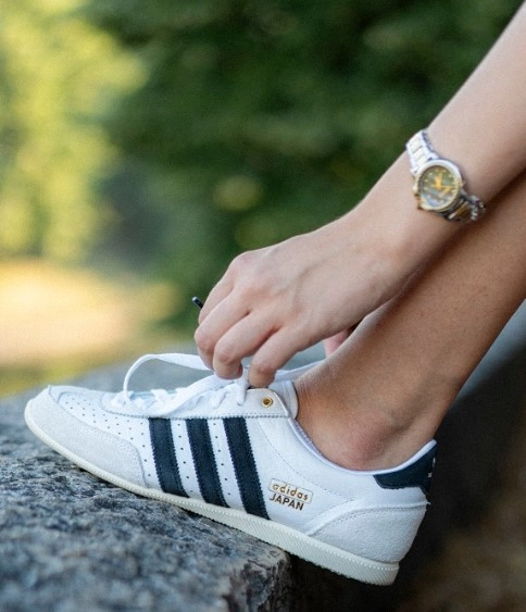 Ruke koje vezuju pertle na bijeloj tenisici