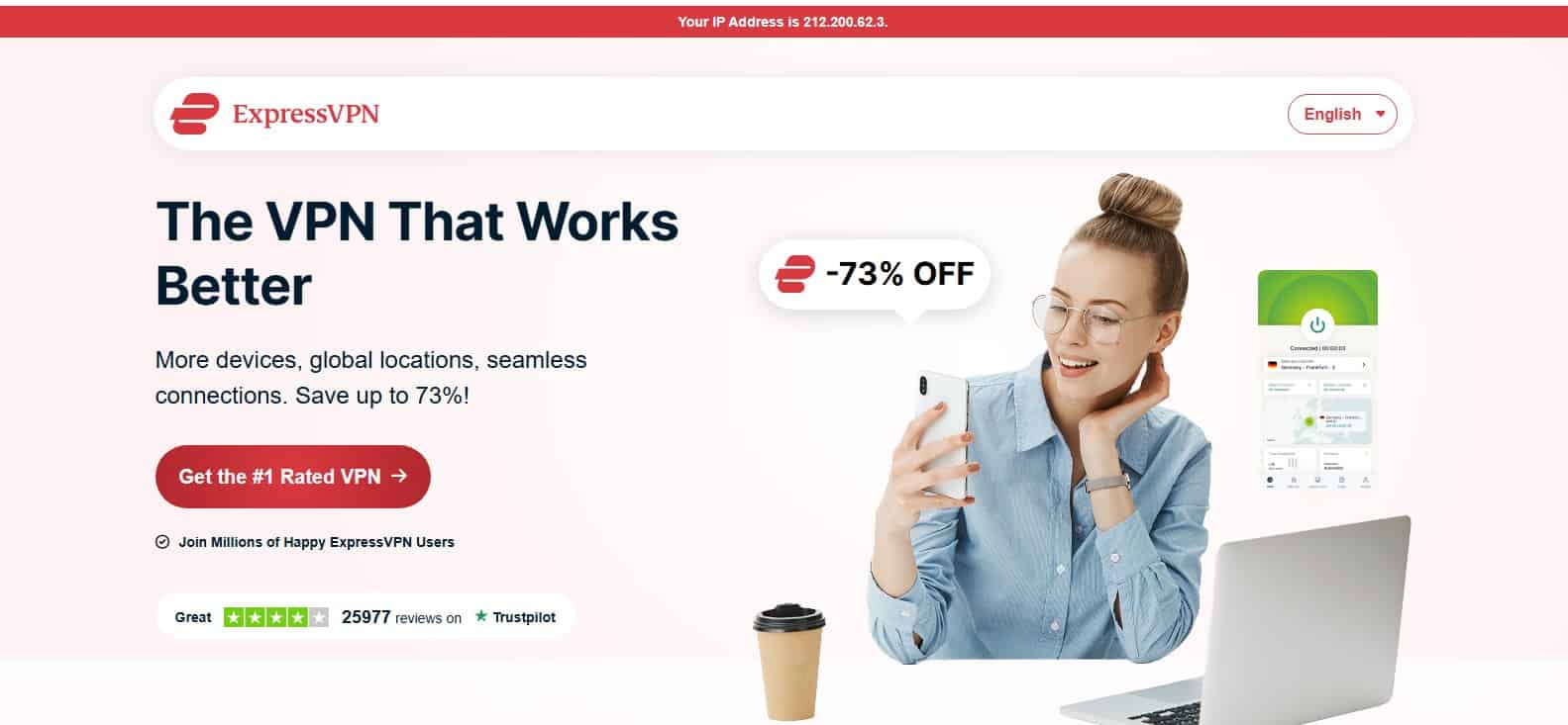 Nasmejana djevojka sedi uz laptop i drži mobitel