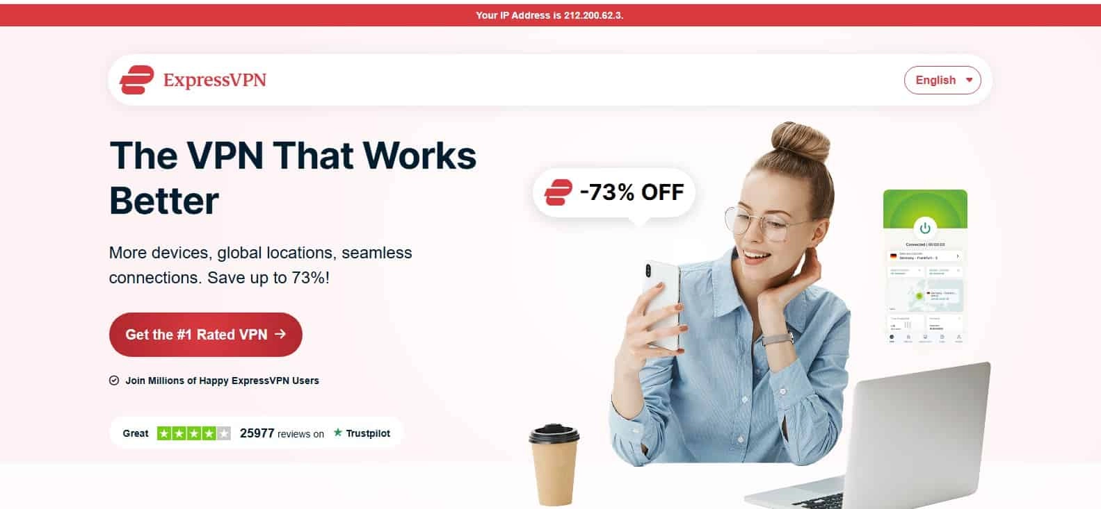 Nasmejana djevojka sedi uz laptop i drži mobitel