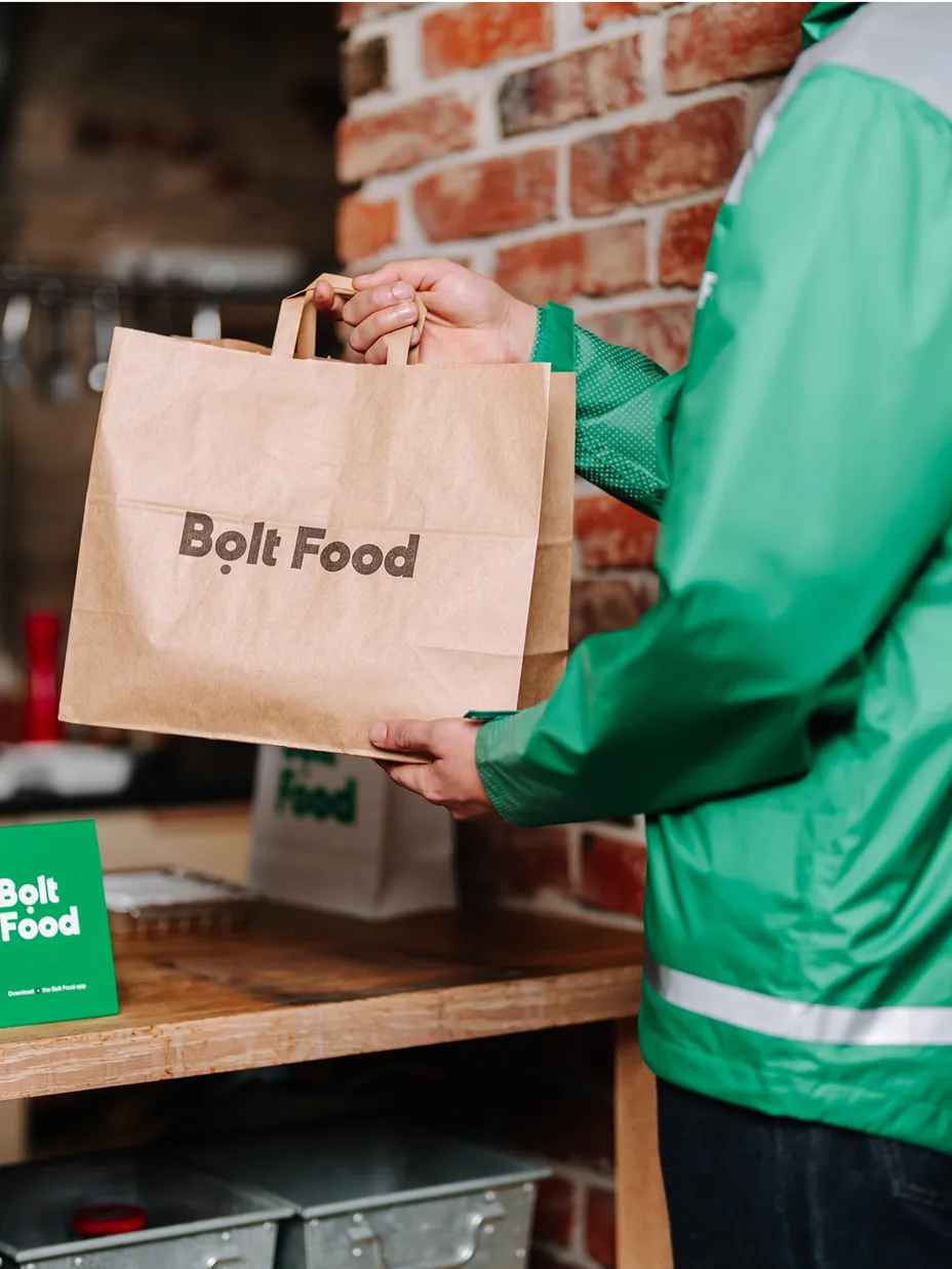 dostavljač hrane donosi hranu u papirnatoj vrećici