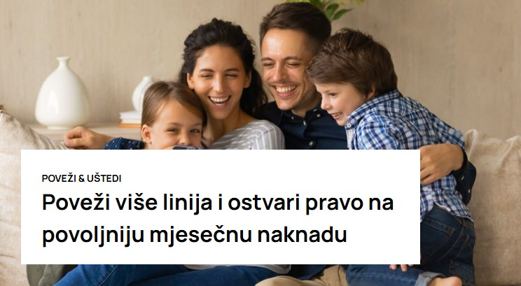 Nasmejana porodica zagrljena sedi na sofi u dnevnoj sobi