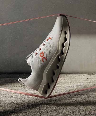 Bijela sportska tenisica u zraku s crvenim detaljima