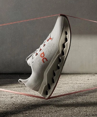 Bijela sportska tenisica u zraku s crvenim detaljima