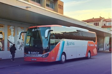 Crveno-beli autobus na autobusnom stajalištu